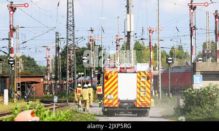 Hannover, Deutschland. 07. September 2022. Feuerwehrleute fahren und gehen durch den Güterbahnhof Seelze in der Region Hannover. Aus bisher unbekannten Gründen sind Lokomotiven in der Station zusammengestoßen. Mehrere Waggons wurden umgedreht oder beschädigt. Ein Wagen soll Salpetersäure tragen. Quelle: Julian Stratenschulte/dpa/Alamy Live News Stockfoto