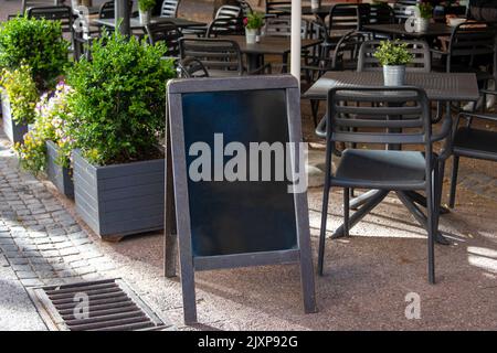 Leeres Restaurantschild oder Menuboard in der Nähe des Eingangs zum Restaurant. Café-Menü auf der Straße. Tafel-Schild vor einem Restaurant. Si Stockfoto