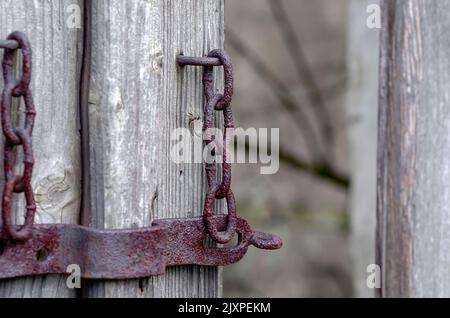 Ein altes rostiges Schloss auf den Überresten einer alten Tür Stockfoto