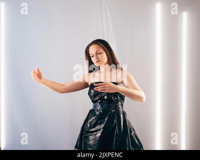 Kunststoff Recycling Frau schwarz Cellophan Kleid Stockfoto