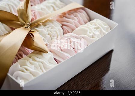 Selbstgemachte weiße und rosa zafhyr in Box mit Schleife auf Holzhintergrund, Draufsicht Stockfoto