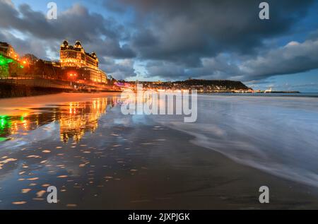 Das Grand Hotel in Scarborough spiegelte sich an einem Abend im Frühling in nassem Sand wider. Stockfoto