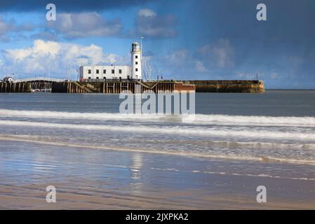 Der Scarborough Lighthouse wurde an einem stürmischen Nachmittag im Frühling von South Beach aus aufgenommen Stockfoto