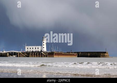 Der Scarborough Lighthouse wurde an einem stürmischen Nachmittag im Frühling von South Beach aus aufgenommen Stockfoto