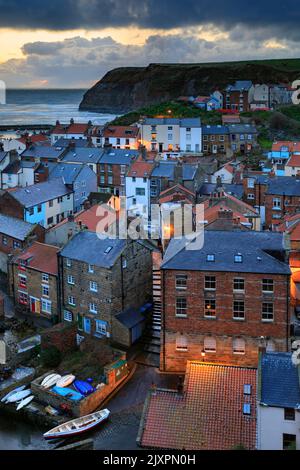 Das malerische Dorf Staithes an der North Yorkshire Coast wurde an einem stürmischen Morgen vor Sonnenaufgang festgehalten. Stockfoto