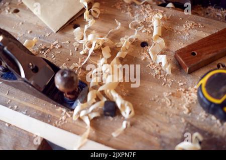 Nahaufnahme Von Holzspännen Und Schreinerei-Werkzeugen Auf Der Werkbank Stockfoto