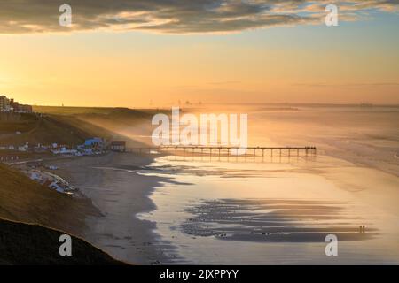 Der Saltburn Pier wurde kurz nach Sonnenaufgang vom Strand aus aufgenommen. Stockfoto