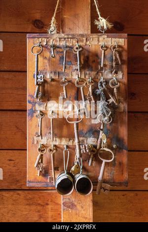 Eine Sammlung alter Schlüssel und Messbecher auf einem Brett in der Hook Norton Brewery, Oxfordshire, England Stockfoto