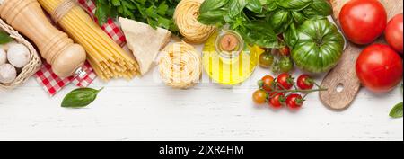 Nudeln, Tomaten und Kräuter. Kochzutaten auf Holztisch. Draufsicht flach liegend Stockfoto