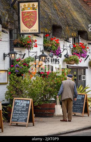 Älterer Mann, der vor einem traditionellen englischen öffentlichen Haus oder in einem Gasthaus in der dorset-Stadt wareham auf der Insel Purbeck, einem traditionellen Pub in großbritannien, steht. Stockfoto