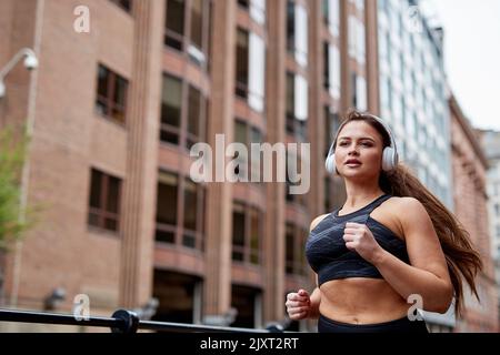 Eine alleinstehende Joggerin auf den Straßen von Manchester, Großbritannien Stockfoto