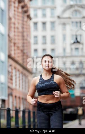 Eine alleinstehende Joggerin auf den Straßen von Manchester, Großbritannien Stockfoto