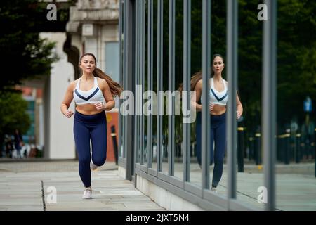 Eine alleinstehende Joggerin auf den Straßen von Manchester, Großbritannien Stockfoto