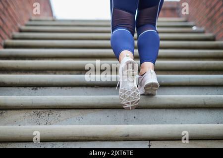 Eine alleinstehende Joggerin auf den Straßen von Manchester, Großbritannien Stockfoto