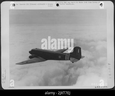 Douglas C-47S, der an das französische Luftkorps überführt und von französischen Besatzungen bemannt wird, hustelt kritische Vorräte bis zu den Advanced Airfields von den riesigen Air Technical Service Command Depots in Großbritannien. Hoch Über Schweren Wolken, Die Den Englischen Chann Umhüllen Stockfoto