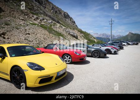 Reihe von Porsche-Sportwagen auf einem Bergparkplatz, Dolomiten, Italien. Stockfoto