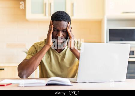 brasilianischer Mann verzweifelt Rechnungen für Zahlungen in der Küche zu überprüfen Stockfoto