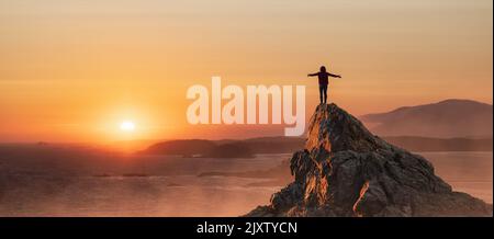 Abenteuerliche Frau Wandern an der Rocky Coast mit Bergen und dramatischem Sonnenuntergang Himmel. Stockfoto