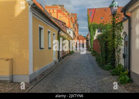 Ystad, Schweden - 6 Sep, 2022: Gepflasterte Straße in einer kleineren südlichen Stadt mit bunten Häusern. Stockfoto