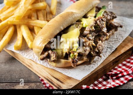 Philly Cheesesteak-Sandwich mit Rindfleisch, Käse, grünen Pepers und karamellisierten Zwiebeln isoliert auf weißem Hintergrund.. Traditionelles philadelphia-Sandwich Stockfoto