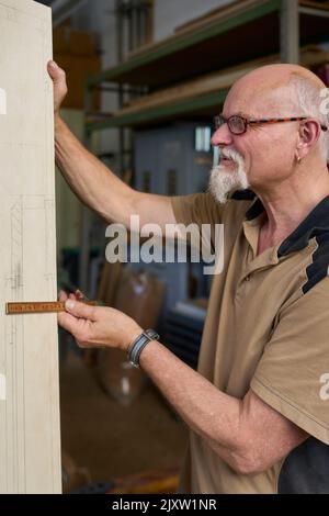 Der Zimmermann Überprüft Die Abmessungen Der Skizze, Die An Das Holz Übertragen Wurde. Russikon, Zürich Oberland, Schweiz Stockfoto