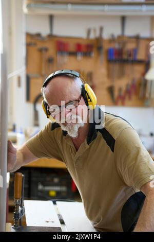 Zimmermann Arbeitet An Der Sägemaschine In Seiner Werkstatt. Russikon, Zürich Oberland, Schweiz Stockfoto