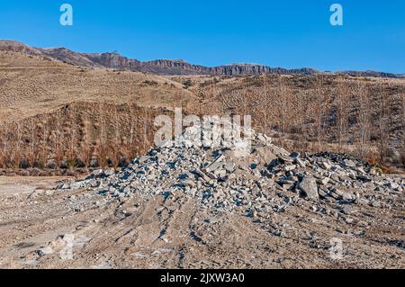 Ein Haufen zerbrochener Beton und Steine in einer großen aktiven Deponie oder Deponie für Feststoffabfälle. Stockfoto