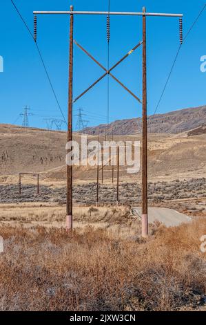 Stromübertragungsleitungen und -Pole in einer aktiven Abfalldeponie. Stockfoto