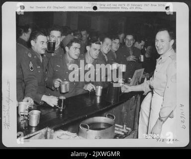 Die Männer, die sich für die Mannschaft eingesandten, werden während Einer Party auf einem Luftwaffenstützpunkt 8. in England mit Erfrischungen versorgt. 29. März 1945. Stockfoto