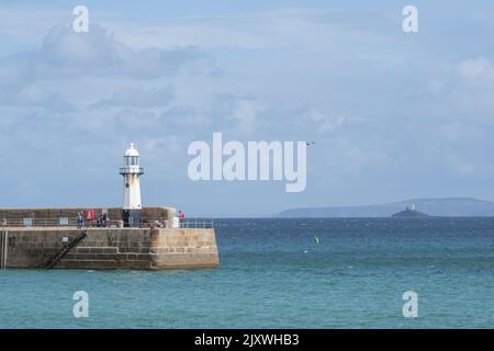 St Ives, Cornwall, Großbritannien. 7. September 2022. UK Wetter: Blick auf den St Ives Lighthouse am Smeaton's Pier an einem Tag mit warmen Sonneneinfällen und schweren Regengüssen im malerischen Badeort St. Ives in Cornwall. Das gemischte Wetter wird diese Woche bestehen bleiben, da Niederdrucksysteme über den Südwesten Englands hinwegfegen. Kredit: Celia McMahon/Alamy Live Nachrichten Stockfoto