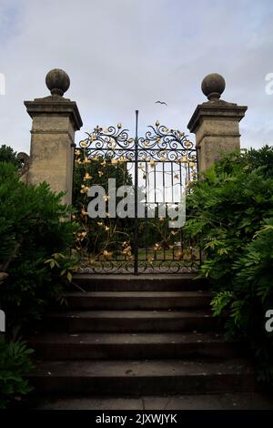 Ornamentale Eisentore mit goldenen und schwarzen Features. St Fagans National History Museum. Sommer 2022. August. Stockfoto