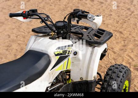 Kinder und Jugendliche Quad-Bike auf dem Sandufer des Sees Stockfoto