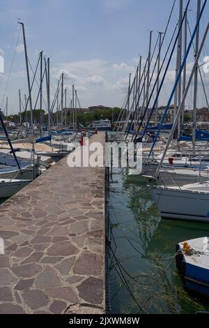 Desenzano del Garda, Italien - 12. Juli 2022 - an einem sonnigen Sommermorgen dockten Yachten und Boote am Hafen am Gardasee an Stockfoto