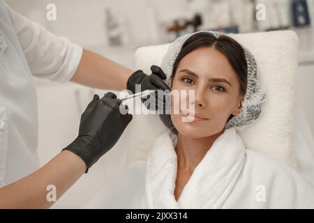 Kosmetikerin macht verjüngende Anti-Falten-Injektionen auf das Gesicht der Frau im Schönheitssalon Stockfoto