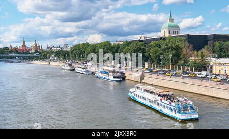 Stadtbild, Blick von der Bolschoj-Ustyinsky-Brücke auf den Moskvoretskaya-Damm, Vergnügungsboote und den Moskauer Kreml: Moskau, Russland - 29. Juli 2022 Stockfoto