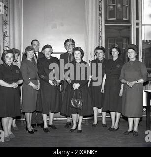 1965 versammelten sich historische Damen der WVS, der Frauenfreiwilligedienste, in einem Raum für ein Foto in Fife, Schottland, Großbritannien, mehrere in ihrer Uniform, mit Emblemen auf ihren Hemden, mit W.V. S Zivilschutz. Heute bekannt als Royal Voluntary Service, war es die Women's Voluntary Services (WVS) von 1938 bis 1966 und dann die Women's Royal Voluntary Service (WRVS) bis 2004, WRVS bis 2013. Sie wurde 1938 als britische Frauenorganisation gegründet, um Frauen für die Air RAID Prescautions (ARP) zu rekrutieren. Die RVS ist eine freiwillige Organisation, die sich mit der Unterstützung von Menschen in Not im gesamten Vereinigten Königreich beschäftigt. Stockfoto