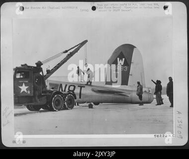 Wenn ein schwerer Bomber nach einem Bombenangriff auf Deutschland in einem verkrüppelten Zustand zu dieser Boeing B-17 zurückkehrt, sind Mitglieder der Bodenbesatzung immer vor Ort, um die notwendigen Reparaturen vorzunehmen. Sobald dieses Flugzeug mit landete Stockfoto