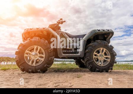 ATV am Sandufer des Sees. Seitenansicht. Stockfoto