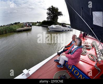 Passagiere, die an Bord eines Vintage-Segelschiffes wherry albion auf dem Fluss Thurne, norfolk england, segeln Stockfoto