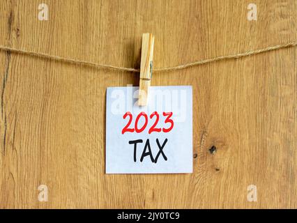 Symbol für 2023 Steuern für das neue Jahr. Weißes Papier mit Worten 2023 Steuer, Clip auf Holzlasche. Schöner Holzhintergrund. Geschäfts- und 2023 Steuern im neuen Jahr konz Stockfoto