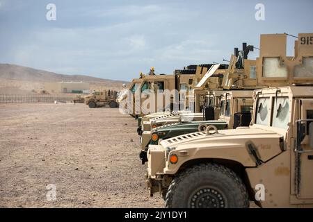 High Mobility Multipurpose Vehicles (HMMWV) und M1082 American Light Medium Tactical Vehicle (LMTV)-Anhänger, die an einem Motorpool vor dem National Training Center in Fort Irwin, Kalifornien, veranstaltet werden, 4. August 2022. Fahrzeuge werden vor und nach Missionen in Motorpools zur Wartung und Inspektion eingesetzt. Stockfoto