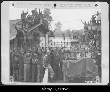 Kriegsgefangene, die im Hanowa Gefangenenlager #6 in Honshu, japanesischer, fröhlicher Gruß 1. LT. Bresnick aus Boston, Massachusetts, interniert wurden, der erste Amerikaner, den sie seit drei oder vier Jahren gesehen haben. 14. September 1945. Stockfoto