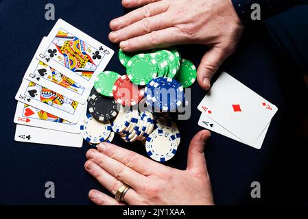 Ein Mann, der ein Paar Asse hält, gewinnt eine Hand Texas Hold'em Poker. Stockfoto