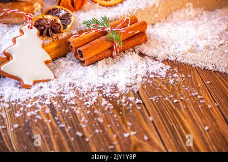Weihnachtsfeiertagskonzept Hintergrund mit weihnachtskeksen, getrockneten Früchten und Gewürzen auf Holzfläche Stockfoto