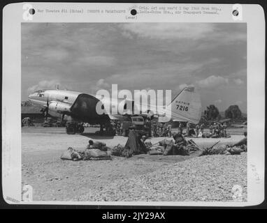 Chinesische Truppen bereiten sich vor dem Einsteigen in dieses Curtiss C-46 'Commando' auf einem Luftwaffenstützpunkt irgendwo in China auf ihre Ausrüstung vor. Stockfoto
