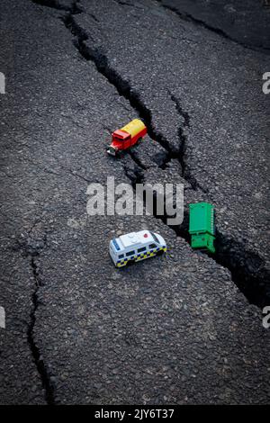 Bunte Auto Spielzeug auf einem geknackten Asphalt Stockfoto