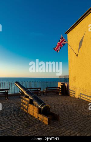 Historischer Kanon und Unionsflagge am Meer in der wunderschönen Küstenstadt Lyme Regis, Dorset Stockfoto