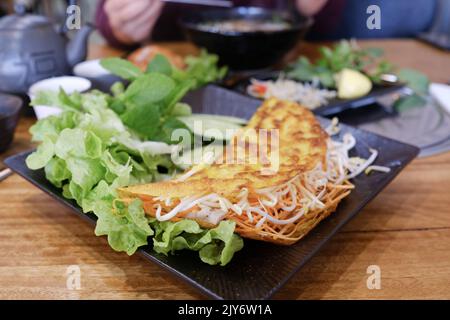 Bánh xèo (knuspriger vietnamesischer Pfannkuchen) mit Garnelen, Schweinefleisch, Mungbohnensprossen und Salat im Me Pho, Bankstown – Sydney, Australien Stockfoto