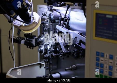 Automatische industrielle CNC-Federwickelmaschine. Selektiver Fokus. Stockfoto