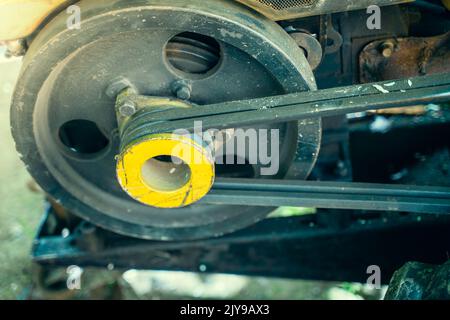 Der Riemenantrieb des ländlichen Motorblocks des Gartens. Angetriebene zweiadrige Riemenscheibe eines Minitraktors Stockfoto